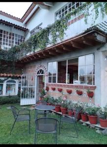 un tavolo e sedie di fronte a una casa di Casa Sauces a Tepoztlán