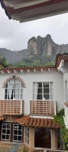 een wit huis met houten balkons met een berg op de achtergrond bij Casa Sauces in Tepoztlán