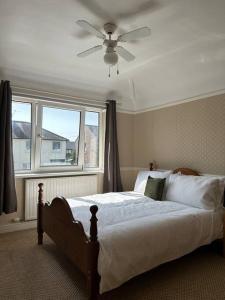 - une chambre avec un lit, un ventilateur de plafond et une fenêtre dans l'établissement Carlisle The Cathedral City And Gateway In Cumbria, à Carlisle