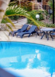 佩里吉安海灘的住宿－格倫伊登海灘度假酒店，一组椅子、一张桌子和一个游泳池