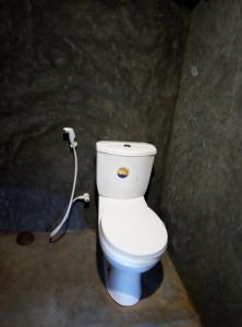 a bathroom with a white toilet with a hose at Meemure WENASA HOTEL in Meemure