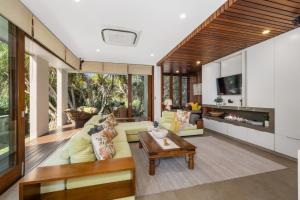 a living room with a couch and a table at Kingscliff Balinese Beachfront Retreat in Kingscliff