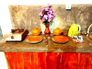 een aanrecht met borden en een vaas met bloemen bij Mount Rest Villa in Hikkaduwa