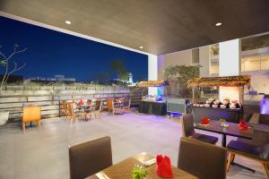 a rooftop patio with tables and chairs at night at Swiss-Belhotel Jambi in Jambi
