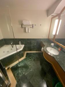 a bathroom with a tub and a sink and a bath tub at Oaks resort in Gold Coast