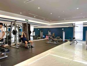 a man exercising in a gym with a woman at New Saigon Royal Luxury Condo 4pax Best City View in Ho Chi Minh City