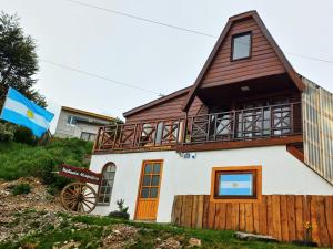 uma casa com uma bandeira em frente em Ushuaia magnífica, cabaña 3 dormitorios em Ushuaia