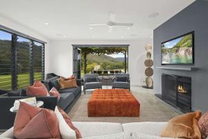 a living room with a couch and a fireplace at Serendipity, Kangaroo Valley in Barrengarry
