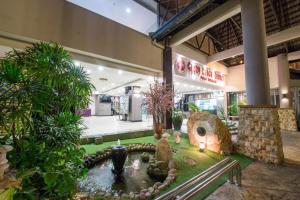 une boutique avec un étang au milieu d'un jardin dans l'établissement Ruiyas Sea View Condominium PortDickson, à Port Dickson