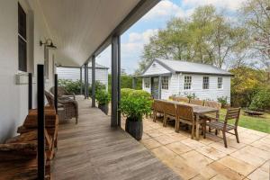 a patio with a table and chairs and a house at Somerset, Berrima, Southern Highlands in Berrima