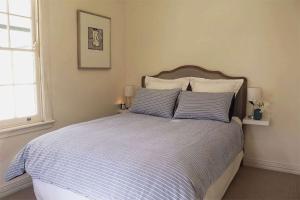 a bedroom with a bed with blue and white sheets at Somerset, Berrima, Southern Highlands in Berrima