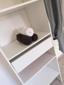 a shelf in a bathroom with towels on it at La villa karukera in Sainte-Rose +32 photos