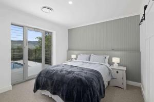 a bedroom with a bed and a large window at Paddington, Kangaroo Valley in Barrengarry