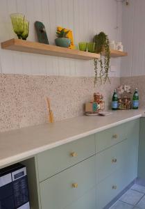 a kitchen with white cabinets and a counter top at JDs Tropical stays in Cairns