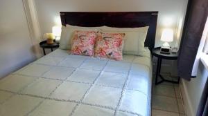 1 dormitorio con 1 cama grande y 2 mesas en JDs Tropical stays en Cairns