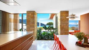 cocina con mesa y sillas y ventana grande en Solina - Ettalong Beach en Ettalong Beach