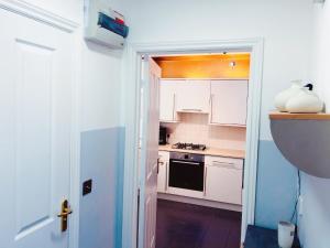 cocina con armarios blancos y fogones en Manchester City home with parking en Mánchester