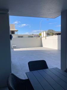 Un balcón con una mesa y sillas en un tejado. en Chilling at the Cayman, en Mount Maunganui