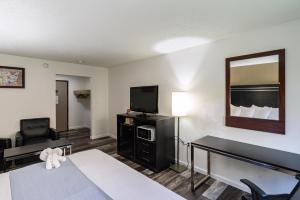 a hotel room with a bed and a flat screen tv at Econo Lodge Cleveland Southeast - Kent in Streetsboro