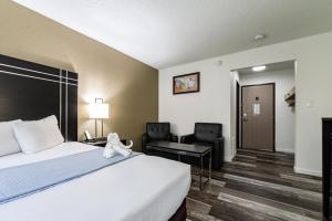een hotelkamer met een bed, een bureau en stoelen bij Econo Lodge Cleveland Southeast - Kent in Streetsboro