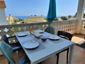 - une table avec des assiettes et des verres à vin sur un balcon dans l'établissement Apartamento Llançà, 3 dormitorios, 7 personas - ES-170-60, à Llançà