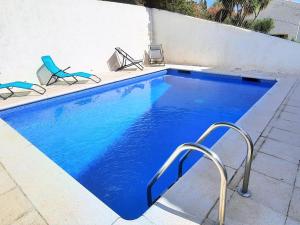 - une piscine avec 2 chaises dans l'établissement Apartamento Llançà, 3 dormitorios, 7 personas - ES-170-60, à Llançà