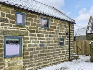 a brick building with windows in the snow at Little Pythorn - Uk45253 in Westerdale