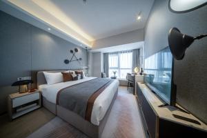 Habitación de hotel con cama y TV en BORUISI Executive Apartment, en Shenzhen