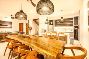 una cucina e una sala da pranzo con tavolo e sedie in legno di Seaside Escape 4br Villa, 190m To Canggu Beach a Canggu