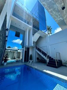 una casa grande con piscina frente a ella en EL Encanto de tu Selva, en Tarapoto
