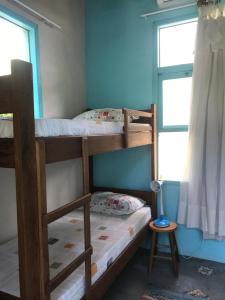 2 Etagenbetten in einem Zimmer mit Fenster in der Unterkunft Paikea Hostel Praia do Rosa in Praia do Rosa