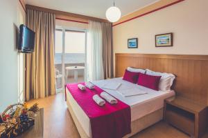 a bedroom with a large bed with a pink blanket at Apartments Deus in Dobra Voda