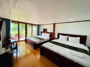 um quarto com 2 camas e uma mesa com uma secretária Sidx Sidx em Chomka Thnong Resort 