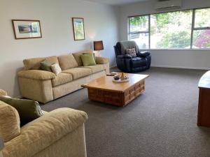 a living room with two couches and a coffee table at Family Adventure Get Away in Rotorua