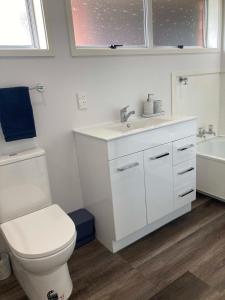 uma casa de banho com um WC, um lavatório e uma banheira em Family Adventure Get Away em Rotorua