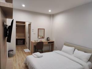 a bedroom with a bed and a desk with a mirror at โฮมเทล in Ban Wang Khanai