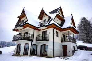 une maison recouverte de neige dans la neige dans l'établissement Apartamenty u Trebuniów, à Suche