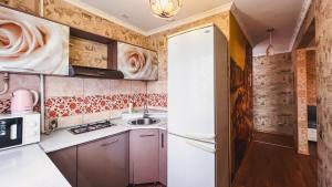 uma cozinha com um frigorífico branco e um lavatório em 1-комнатная квартира Виктория посуточно в центре города Петропавловска рядом с ТРЦ пожить em Petropavl