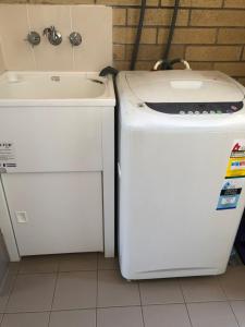 een wasmachine en droger naast een wastafel bij Unit 4 Pattison in Emu Park