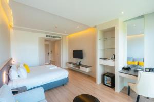 a hotel room with a bed and a television at De VeraNiO Resort in Ban Mai Rut