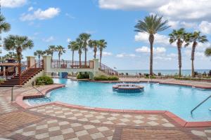 a large swimming pool with palm trees and a boat at Shores Of Panama 1403 in Panama City Beach