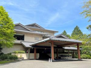 una casa con un cenador frente a ella en Ryuguden en Hakone