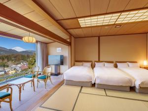 a hotel room with two beds and a television at Ryuguden in Hakone