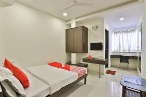 a bedroom with a bed and a desk and a television at Hotel Isher International in Gandhinagar