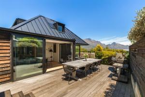 a house with a wooden deck with a table at Mountain Utopia in Queenstown