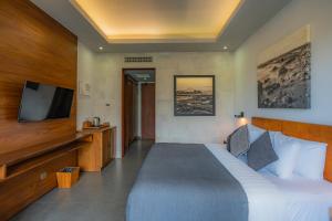 Una habitación de hotel con una cama y un televisor de pantalla plana. en Akana Boutique Hotel, en Sanur