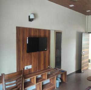 a living room with a tv on a wall at Whyt Bank Cottage Comfort Stays in Mussoorie