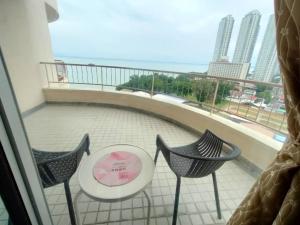 a balcony with two chairs and a table at Seaview Deluxe Studio couples room S in Tanjung Bungah +1 photo