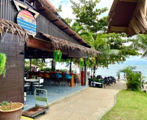 a restaurant on the beach with tables and chairs at Seaview Deluxe Studio couples room S in Tanjung Bungah