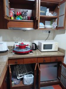 a kitchen with a counter with a microwave and a counter sidx sidx at Villa Dalam Laut 538 in Pantai Cenang